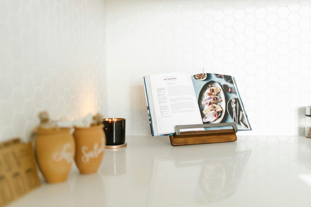 An open cookbook on a modern wooden stand in a stylish kitchen setting, perfect for culinary inspiration.